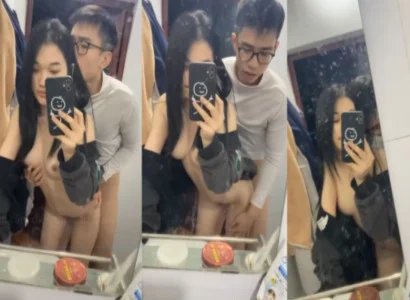 Đôi sinh viên trẻ nện nhau trước gương